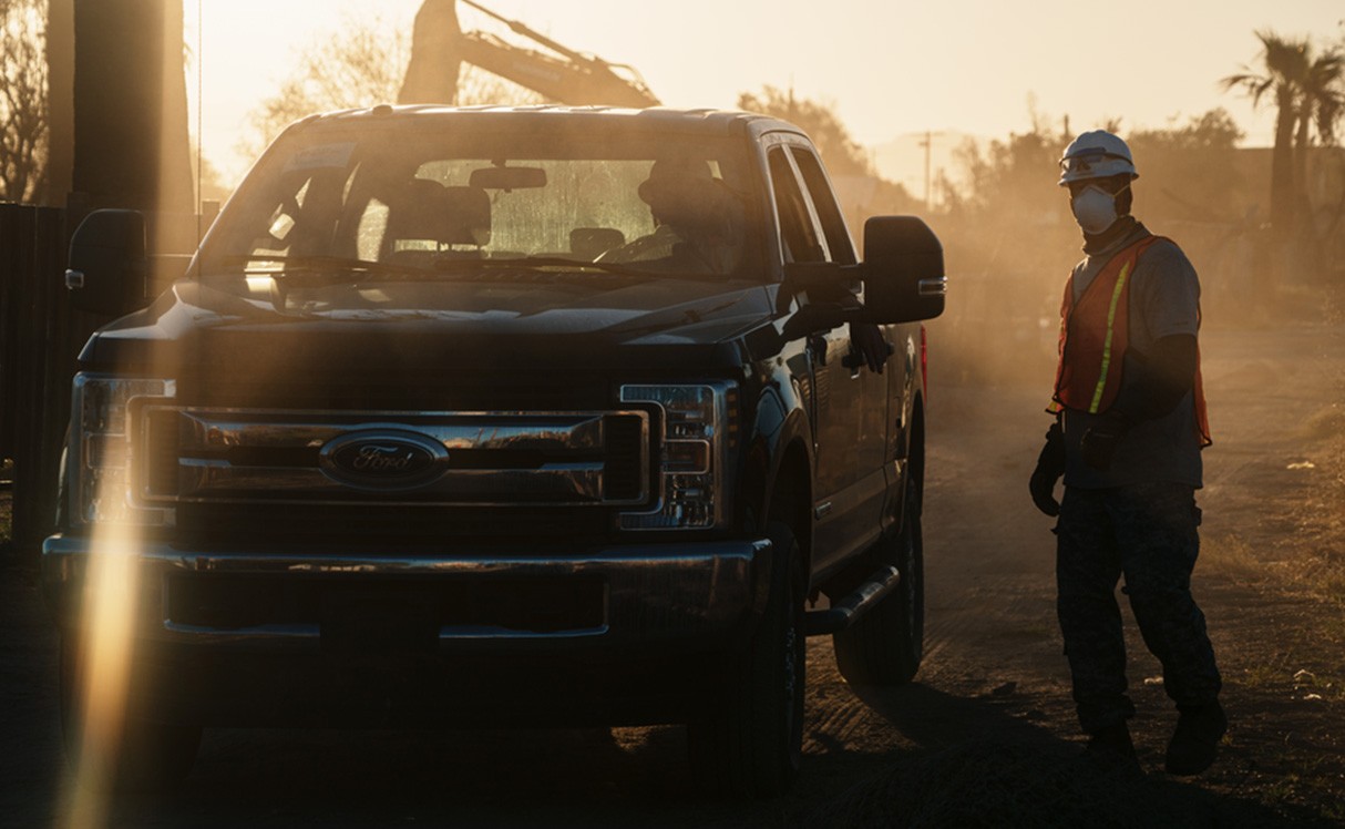 A construction worker is by a Ford truck